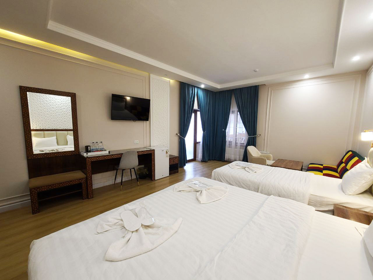 Inviting deluxe family room in the hotel showcasing a large double bed and a desk