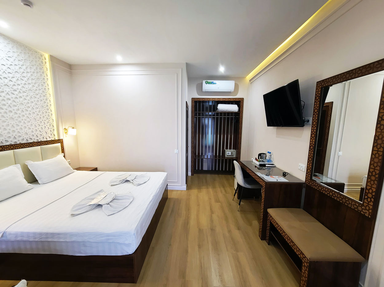 Cozy double room featuring a comfortable bed, desk, and wardrobe