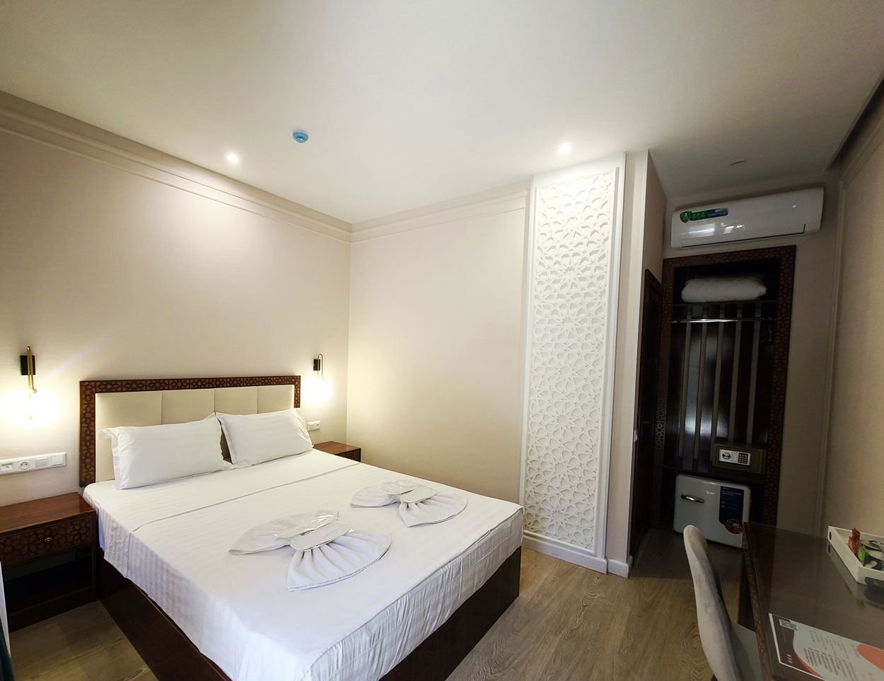 Cozy standard queen room featuring a comfortable bed, desk, and wardrobe