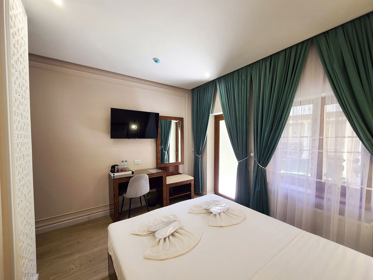 Spacious queen hotel accommodation with double bed, desk, fridge, safe and wardrob